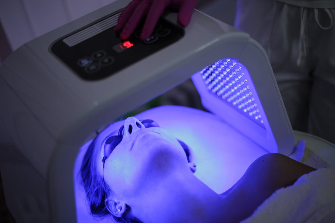 Young woman on light therapy in beauty salon. Omega Light Therapy