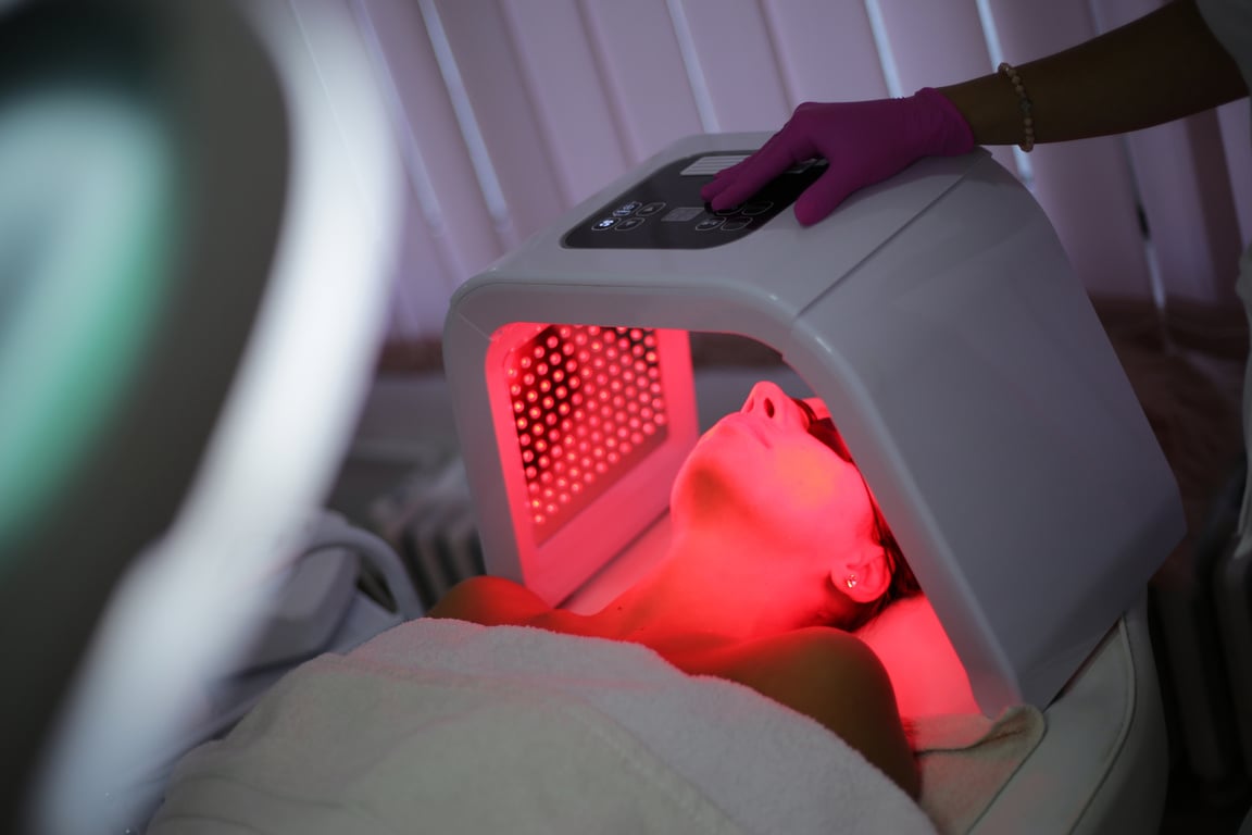 Young woman on light therapy in beauty salon. Omega Light Therapy